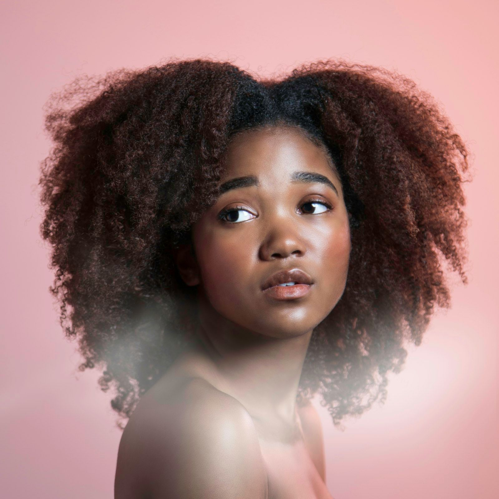 Portrait of a woman with natural curls on blush