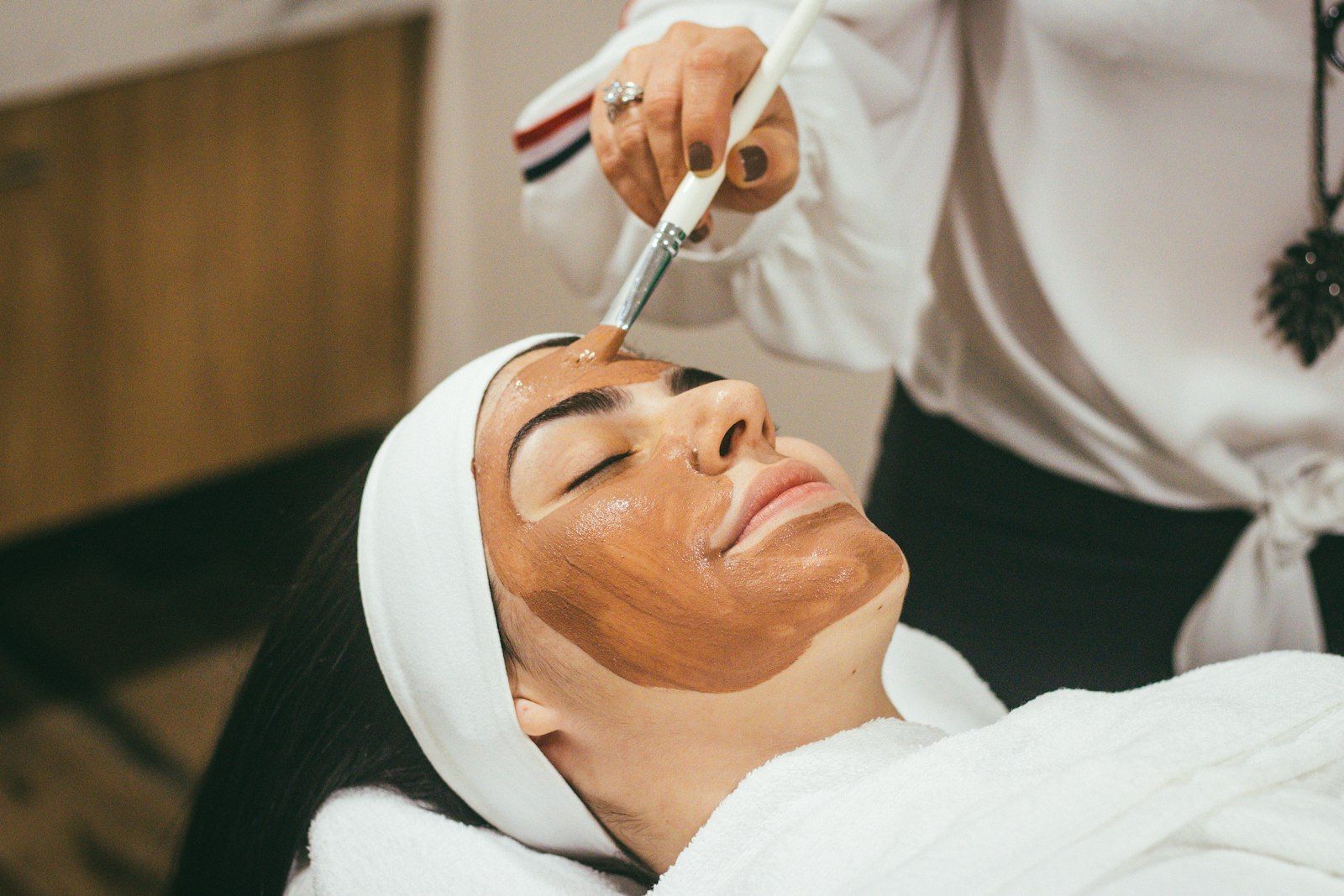 A therapist applying a clay mask during a facial
